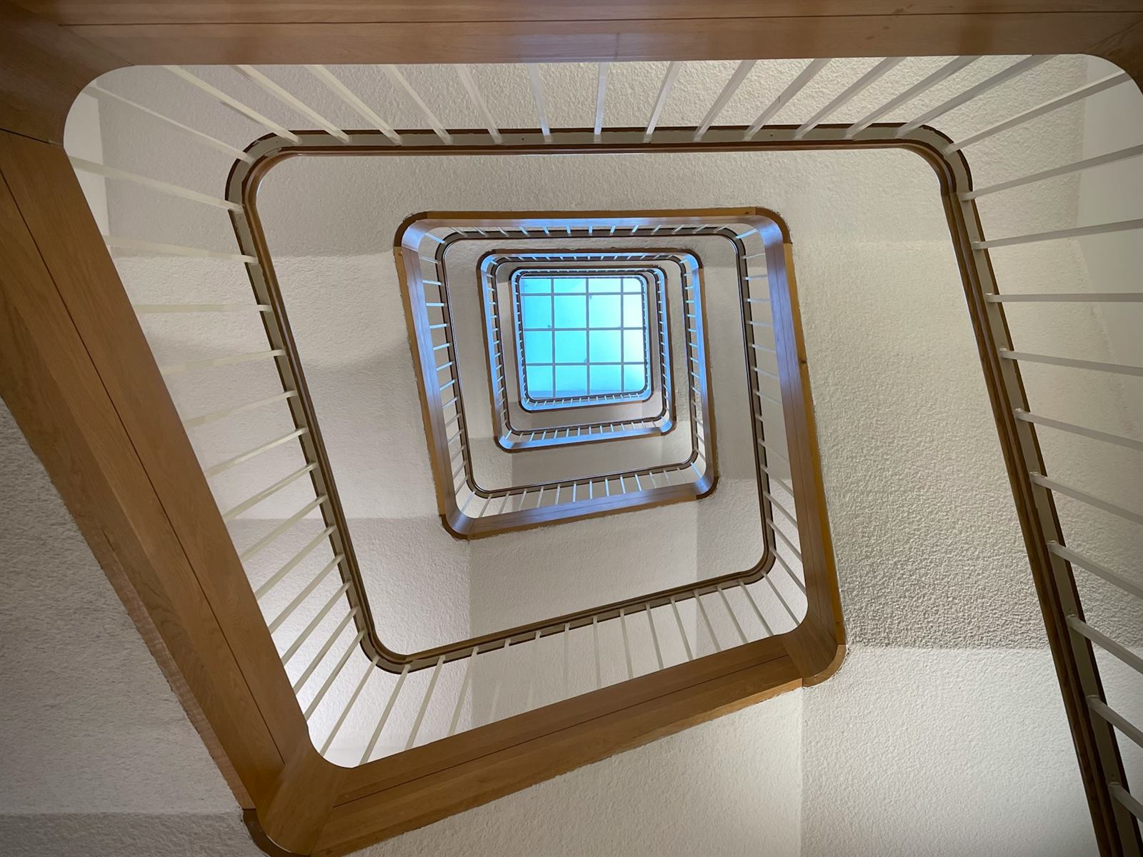 Cage d'escalier carrée vue en plongée, montrant les volées et les virages successifs