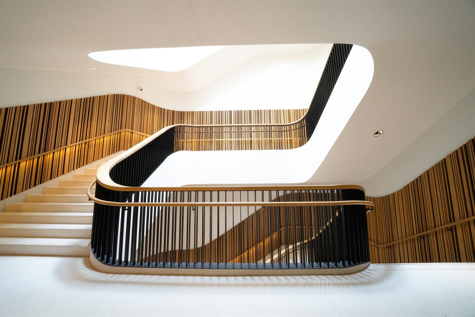 Escalier design à courbe blanche et noire, limon continu épousant la volée