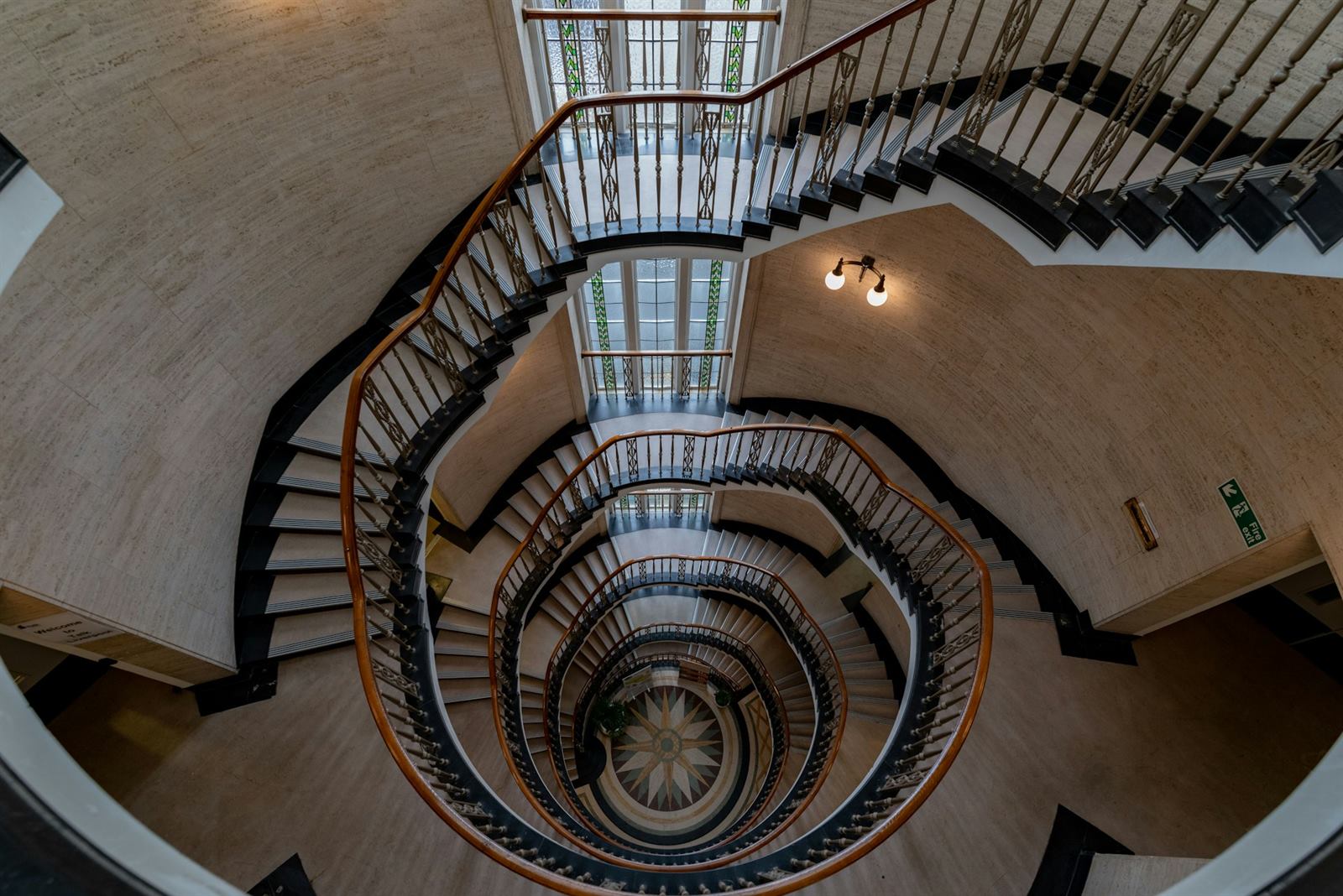 Escalier hélicoïdal vu en plongée, marches enroulées autour du vide central