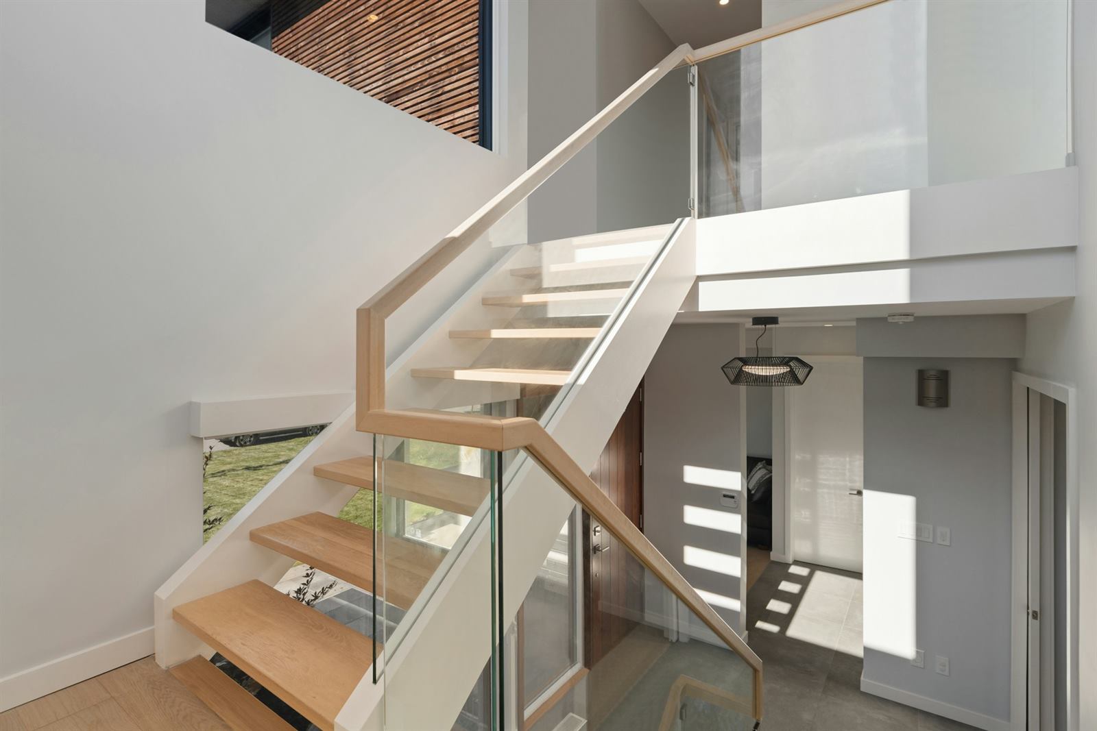 Garde-corps d'escalier en verre et bois, détail de la main courante